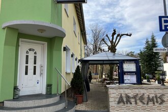 Eingang des Restaurant Artemis mit grüner Hauswand