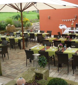 Große Gartenterrasse mit Tischen, Stühlen und Sonnenschirm | © Touristikgemeinschaft Hohenlohe e. V. | Sinzingers Krone