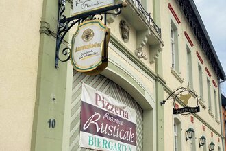 Eingang zum Ristorante Rusticale in Meckesheim mit Informationsschildern.