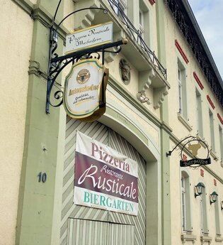 Eingang zum Ristorante Rusticale in Meckesheim mit Informationsschildern.