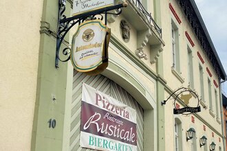 Eingang zum Ristorante Rusticale in Meckesheim mit Informationsschildern.