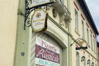 Eingang zum Ristorante Rusticale in Meckesheim mit Informationsschildern.