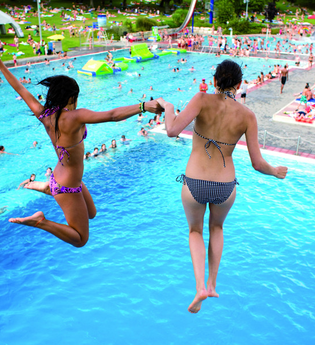 Zwei Frauen springen Hand in Hand in ein Schwimmbecken im Schenkenseebad. | © Schenkenseebad