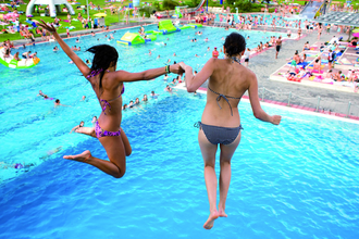 Zwei Frauen springen Hand in Hand in ein Schwimmbecken im Schenkenseebad. | © Schenkenseebad
