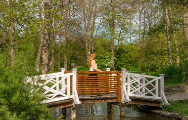Eine Frau läuft über eine kleine Holzbrücke | © Thorsten Günthert