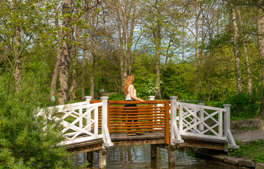 Eine Frau läuft über eine kleine Holzbrücke | © Thorsten Günthert