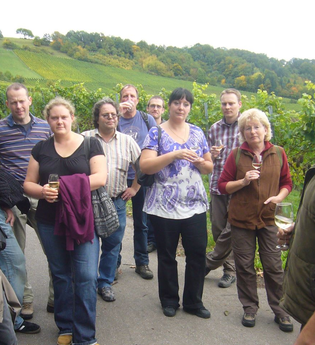 Ein Mann führt eine Gruppe Erwachsener bei einer Weinprobe | © Touristikgemeinschaft Hohenlohe e. V.