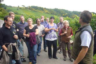 Ein Mann führt eine Gruppe Erwachsener bei einer Weinprobe | © Touristikgemeinschaft Hohenlohe e. V.