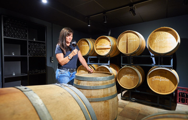 Alexandra Siller probiert aus einem Weinfass im Keller | © Touristikgemeinschaft Hohenlohe e. V.