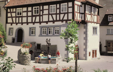 Fachwerkfassade mit Brunnen, in dem sich das Museum befindet | © Touristikgemeinschaft Hohenlohe e. V. | Eva Maria Kraiss