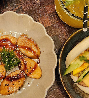 Veganer Teller mit Teigtaschen, Bao Bun und Getränk. | © SMG