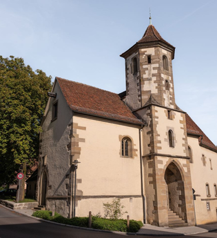 Zu sehen ist eine alte Kirche mit Turm an einer Straße | © Stadverwaltung Crailsheim
