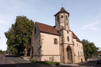 Zu sehen ist eine alte Kirche mit Turm an einer Straße | © Stadverwaltung Crailsheim