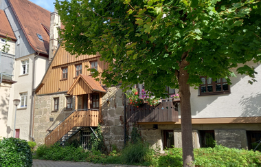 Historische Gebäude in Gaildorf mit Fachwerk und Baum im Vordergrund. | © Petra Natzkowski