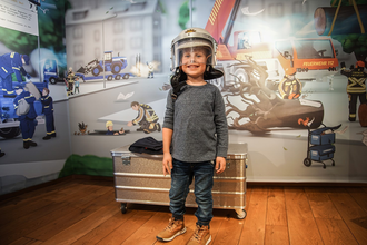 Kind mit Feuerwehrhelm in der BLAULICHT Ausstellung | © Stadtmuseum Neckarsulm