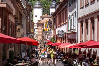 Bummel durch die Steingasse, im Hintergrund die Brückentürme der Alten Brücke | © Heidelberg Marketing GmbH / Tobias Schwerdt
