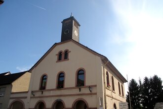 Gebäude mit Glockenturm vor blauem Himmel | © Maria Zimmermann