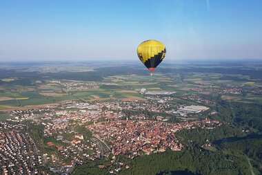 Ballon in der Luft über einer kleinen Stadt im Grünen | © Touristikgemeinschaft Hohenlohe, Künzelsau