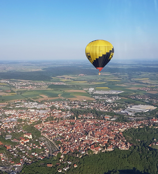 Ballon in der Luft über einer kleinen Stadt im Grünen | © Touristikgemeinschaft Hohenlohe, Künzelsau