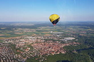 Ballon in der Luft über einer kleinen Stadt im Grünen | © Touristikgemeinschaft Hohenlohe, Künzelsau