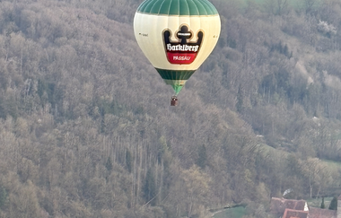 Ein grüner Heißluftballon schwebt über der Hohenloher Landschaft | © Touristikgemeinschaft Hohenlohe | Alexander Boesel