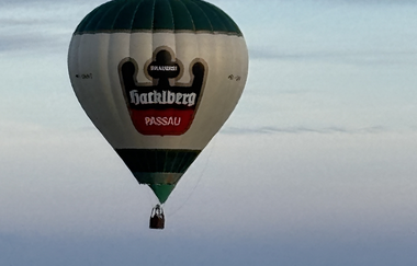 Ein Heißluftballon schwebt am Himmel mit Wolken im Hintergrund | © Touristikgemeinschaft Hohenlohe | Alexander Boesel