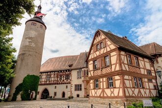 Blick auf das Tauberfränkische Landschaftsmuseum in Tauberbischofsheim. Zwei Gebäude sind im Fachwerkstil errichtet. Daneben ist der Türmersturm zu sehen. | © Tourismusverband "Liebliches Taubertal" e.V.