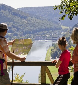 Wanderer stehen am Geländer an der Teufelskanzel, im Hintergrund sieht man den Neckar und die Schleuse | © Andreas Held