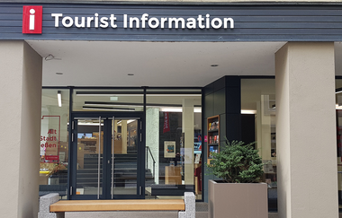 Eingang zur Tourist Information in Schwäbisch Hall mit Glasfront und Informationsmaterialien. | © Leoni Friedrich