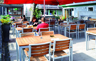 Auf der Terrasse stehen Tische, Stühle und rote Sonnenschrime | © Touristikgemeinschaft Hohenlohe e. V. | Bäckerei Trunk