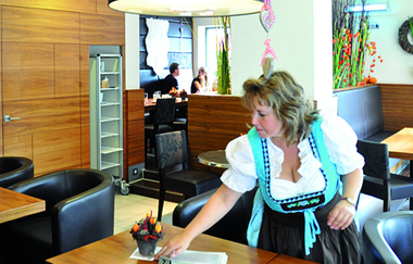 Eine Frau deckt einen Tisch ein | © Touristikgemeinschaft Hohenlohe e. V. | Bäckerei Trunk