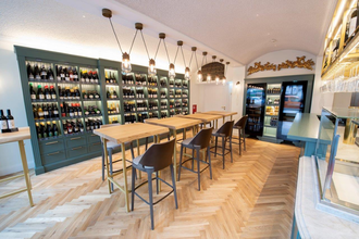 In der Vinothek gibt es Tische und Stühle, an der Wand stehen große Flaschenregale | © Touristikgemeinschaft Hohenlohe e. V.  | Hotel Anne-Sophie