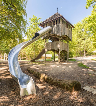 Zu sehen ist ein Holzturm mit Rutsche umgeben von Bäumen | © Stadtverwaltung Crailsheim