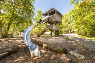 Zu sehen ist ein Holzturm mit Rutsche umgeben von Bäumen | © Stadtverwaltung Crailsheim