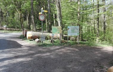 Hinweisschilder und Übersichtskarten an einem Waldweg
