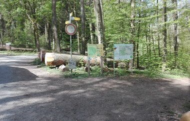 Hinweisschilder und Übersichtskarten an einem Waldweg