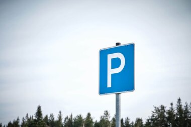 Ein blaues Parkplatzschild vor Wald und Himmel | © TMBW