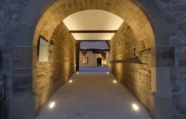 Stimmungsvoll beleuchteter Durchgang im historischen Wasserschloss Sachsenheim. | © Stadt Sachsenheim