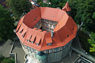 Luftaufnahme des historischen Wasserschlosses in Sachsenheim, umgeben von Bäumen und malerischer Natur. | © Stadt Sachsenheim