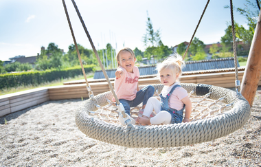 Zwei kleine Kinder ein einer Netzschaukel auf dem Wasserspieltplatz Eppingen. | © Stadt Eppingen