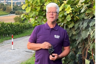 Weinerlebnisführer Klaus P. Weibler mit Weintrauben in der Hand | © Touristikgemeinschaft Hohenlohe e.V. | Klaus P. Weibler