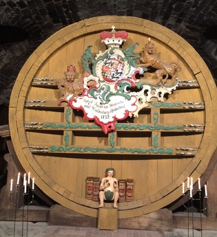 Im Museum steht ein großes altes Weinfass, davor sind Kerzen angezündet | © Touristikgemeinschaft Hohenlohe e. V. | Marion Schlund