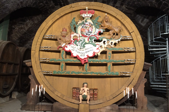 Im Museum steht ein großes altes Weinfass, davor sind Kerzen angezündet | © Touristikgemeinschaft Hohenlohe e. V. | Marion Schlund