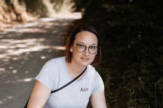 Die Weinerlebnisführerin kniet auf einem Weg und holt eine Flasche Wein aus einer Kiste | © Touristikgemeinschaft Hohenlohe e. V. | Anja Herterich