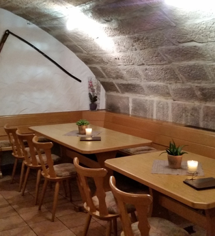 In der Weinstube stehen rustikale Tische und Stühle | © Touristikgemeinschaft Hohenlohe e. V. | Weingut Borth