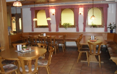 Im Raum stehen rustikale Holztische und Stühle | © Touristikgemeinschaft Hohenlohe e. V.