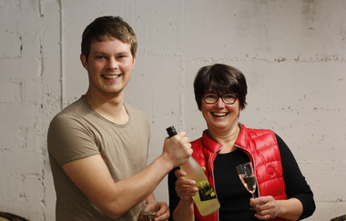 Susanne und Gerrit Schmezer halten zwei Flaschen Wein in den Händen | © Touristikgemeinschaft Hohenlohe e. V. |  Weingut Gaufer