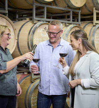 Regina Birkert lässt ein Paar Wein im Keller probieren | © Touristikgemeinschaft Hohenlohe e.V. | Andi Schmid