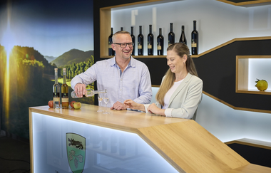 In der modernen Vinothek steht ein Paar und probiert Weine | © Touristikgemeinschaft Hohenlohe e.V. | Andi Schmid