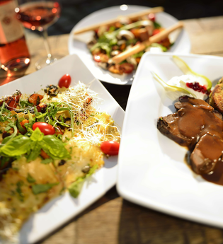 Drei ansprechend angerichtete Teller mit regionalen Spezialitäten und ein Glas Roséwein auf einem Holztisch. | © Kraichgau-Stromberg Tourismus e.V.